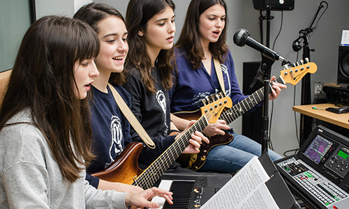 4 filles dans un studio jouant de la musique